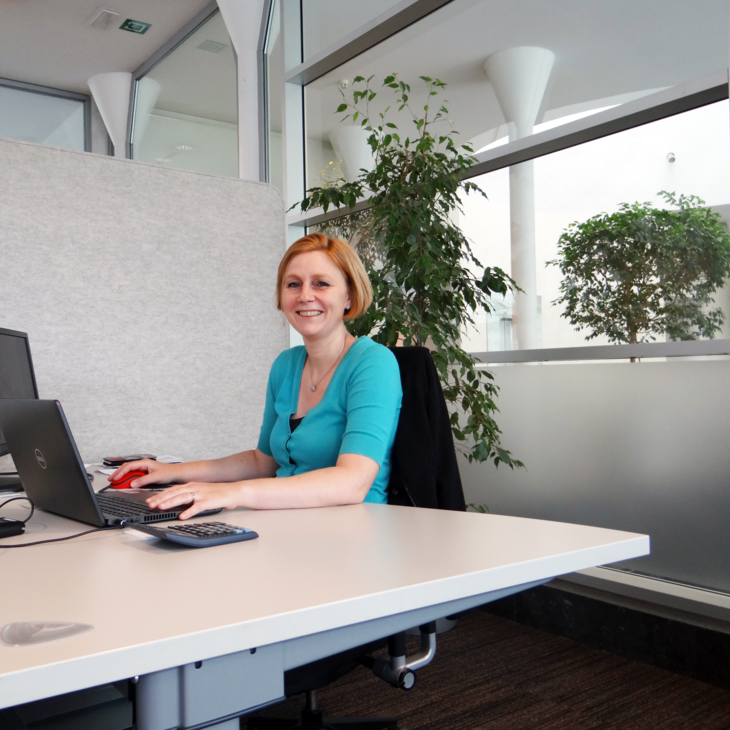 Collega Kirsten werkt aan haar bureau op kantoor