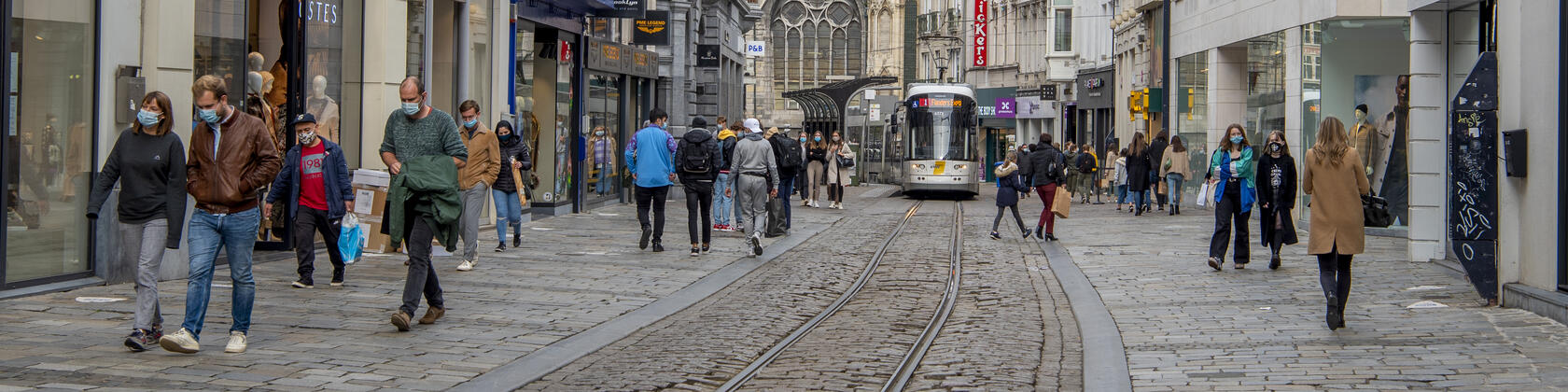 Verschillende mensen lopen door de Veldstraat in Gent, allemaal op veilige afstand van elkaar en met een mondmasker op
